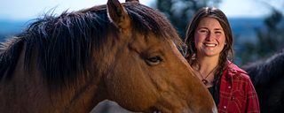 Portrait of Landra Skovalin and a horse at the Minam River Lodge