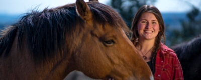 Portrait of Landra Skovalin and a horse at the Minam River Lodge